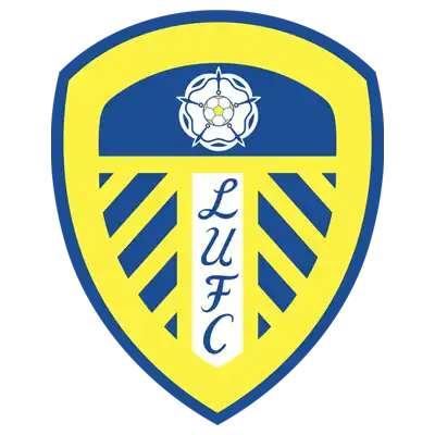 Yellow and blue shield-shaped soccer team logo with a white lily flower in the center.